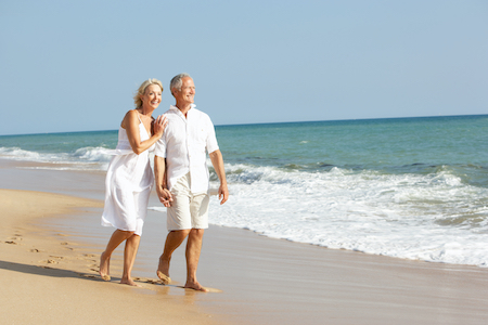 Older couple walking on beach